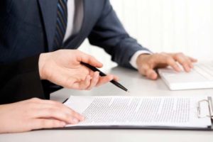 Female hands with a pen over contract